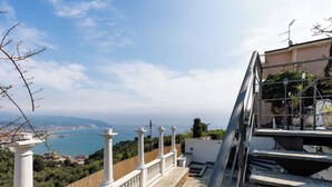 Ein Balkon mit Blick auf das Meer und die Stadt.