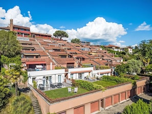 A residential area with terraced houses, a rooftop garden, and a clear blue sky.