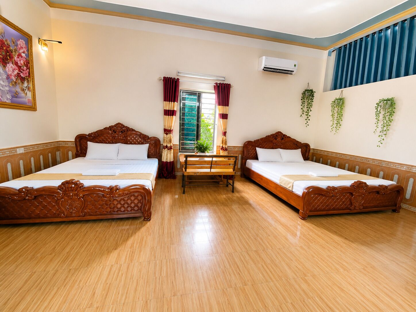 A room with two wooden beds, a window with curtains, an air conditioning unit, and hanging plants.