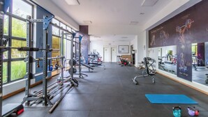 A gym with exercise equipment, a blue mat, kettlebells, and large windows. - Nova 2-bedroom apartment in Nairobi (Nairobi)