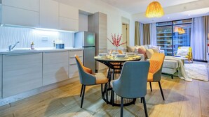 A modern kitchen with a dining area, a sofa, and a yellow chair. - Nova 2-bedroom apartment in Nairobi (Nairobi)