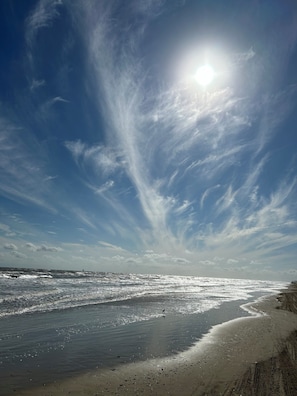 A beach with waves, a clear sky, and a bright sun. - 3-bedroom/2 bath house in the beautiful Sandy Shores neighborhood. (Bolivar Peninsula)