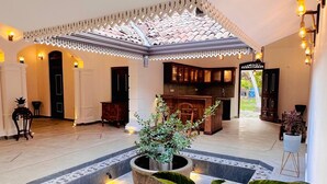 A spacious indoor area with a central courtyard, a kitchen area, and a seating area with a view. - The Ridgecolonial Villa 10 min Walk to Beach (Ahangama)
