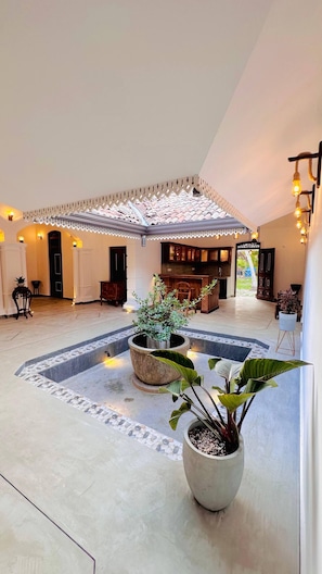 A spacious indoor area with a central courtyard, a kitchen area, and a seating area with a view. - The Ridgecolonial Villa 10 min Walk to Beach (Ahangama)
