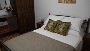 A bedroom with a bed, a dresser, a mirror, and a door. - Art House by Helen in Soroni Rhodes (Rhodes)