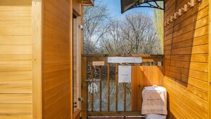 Der Saunagang: Holzvertäfelung, Glastür, Hinweisschild mit Saunabeschreibungen und ein Handtuch auf dem Boden.