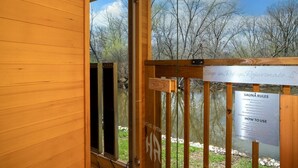 Eine Holzhütte mit einem Schild für die Sauna und den dazugehörigen Regeln.