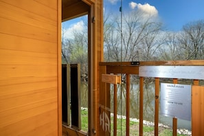 Eine Holzhütte mit einem Schild für die Sauna und den dazugehörigen Regeln.