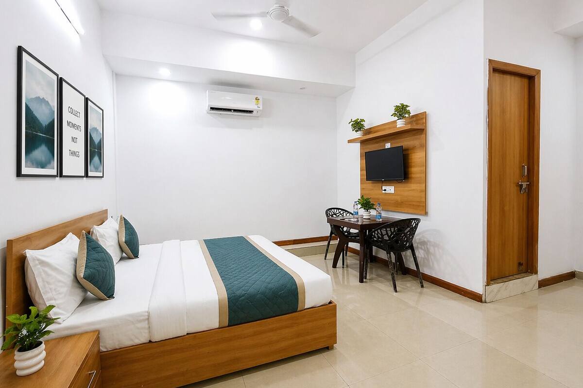 Une chambre à coucher comprenant un lit, une table de chevet et un bureau avec des chaises.