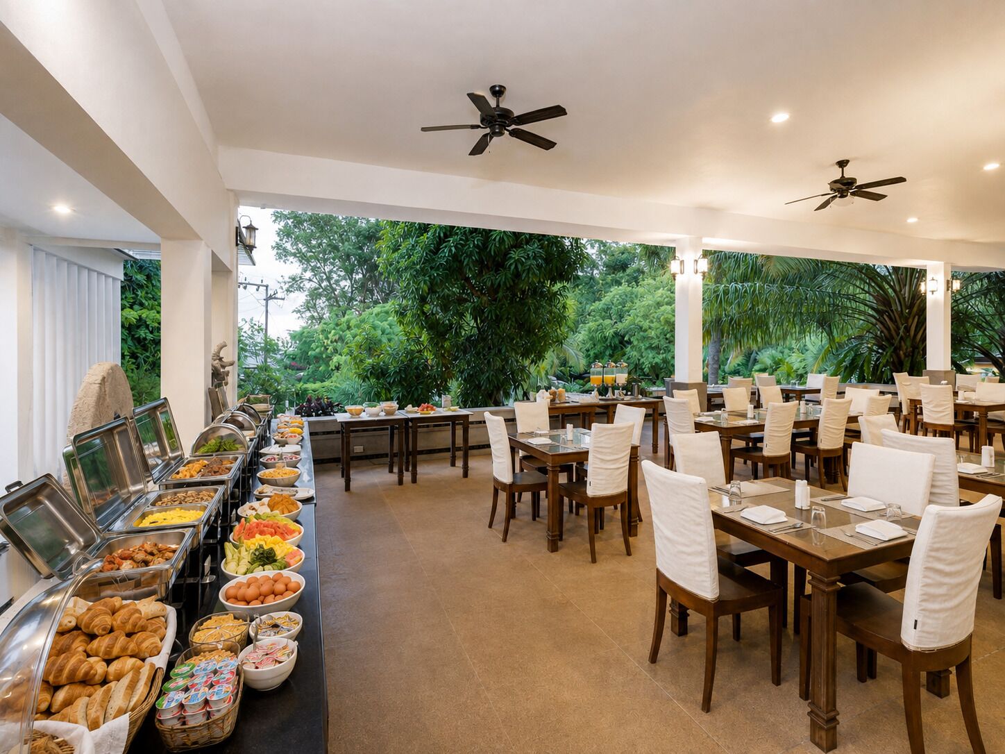 Un área de desayuno tipo buffet con diversas opciones de comida, incluyendo frutas, pasteles y cereales.