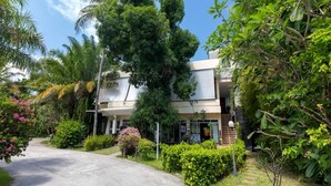 A modern two-story building with a paved driveway leading to the entrance. - Blue Palm Seafront Resort Phuket (Rawai)