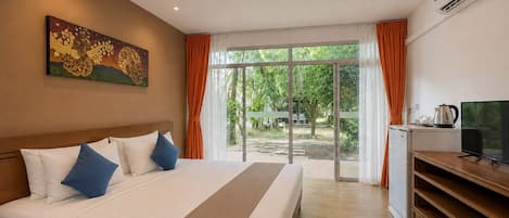 A hotel room with a bed, a television, an air conditioning unit, and a view of the outdoors.