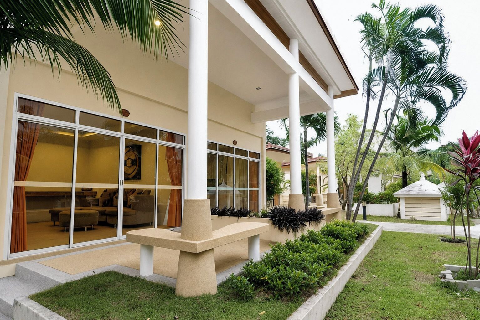 A modern house with a covered porch, large windows, and a well-maintained lawn.