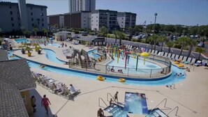 A resort with a large pool area, including a water slide and multiple swimming pools.