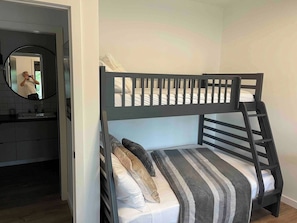 A bunk bed with a ladder, a mirror, and a sink in a small room. - Serene 6-bedroom Retreat in Tory Hill With Lake Views (North Kawartha)