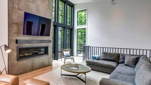 A modern living room with a fireplace, a sofa, a coffee table, and a television.