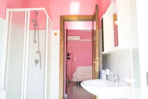 Ein Badezimmer mit Dusche, Waschbecken und Spiegel.