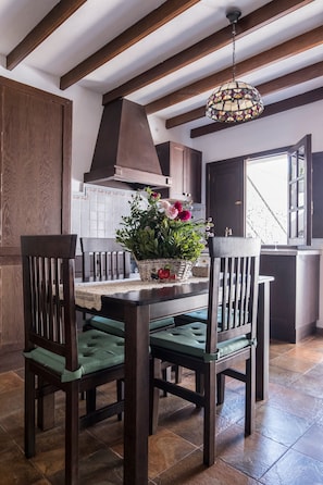 Un espace repas comprenant une table en bois, des chaises et un luminaire suspendu.