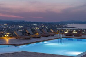 A rooftop pool with lounge chairs and a cityscape view at dusk. - Lithea Seaview Villa & Estate (Chania)