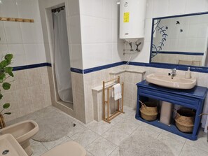 Ein Badezimmer mit Dusche, Waschbecken und Spiegel.