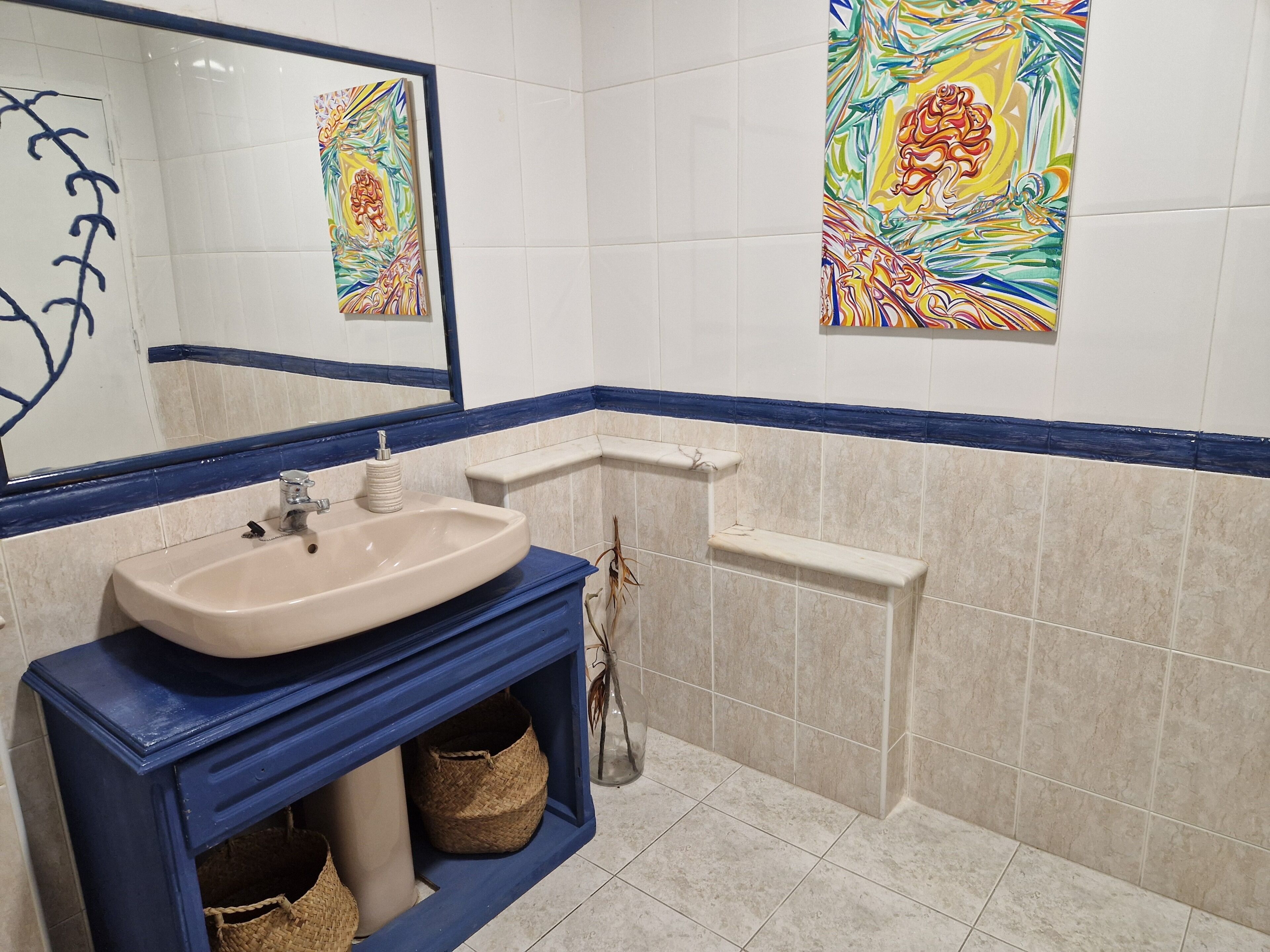 A bathroom with a sink, mirror, and tiled walls.