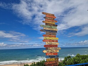 A wooden signpost with city names and distances.