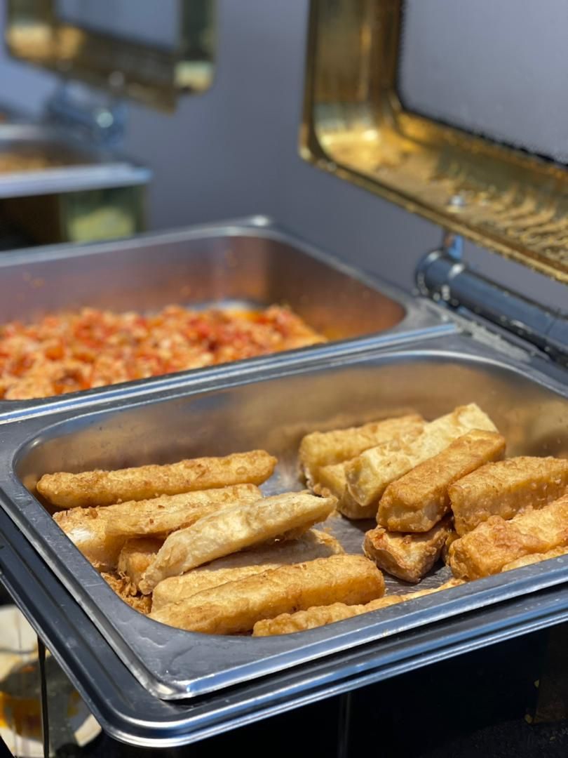 A buffet with fried items and a tomato-based dish.