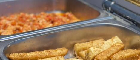 A buffet with fried items and a tomato-based dish.