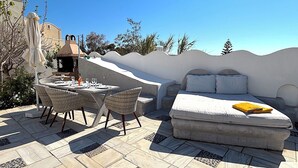 A rooftop terrace with a dining table, chairs, a sofa, and a grill. - Villa Gala (Kamari)
