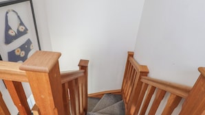 A wooden staircase with a carpeted landing. - Kiloran (Rhosneigr)