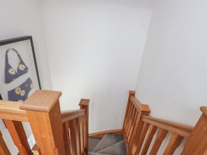 A wooden staircase with a carpeted landing. - Kiloran (Rhosneigr)