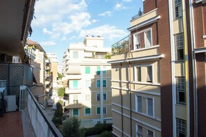 A multi-story residential building with balconies, a visible air conditioning unit, and a clear sky. - Orietta Boutique Apartment, Trastevere Station (Roma)