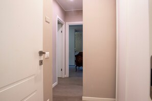 Un pasillo con una puerta que da a una habitación con pared decorada.
