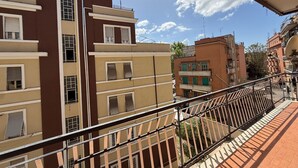 Un edificio residenziale a più piani con balconi, cielo sereno e tetto a tegole rosse.