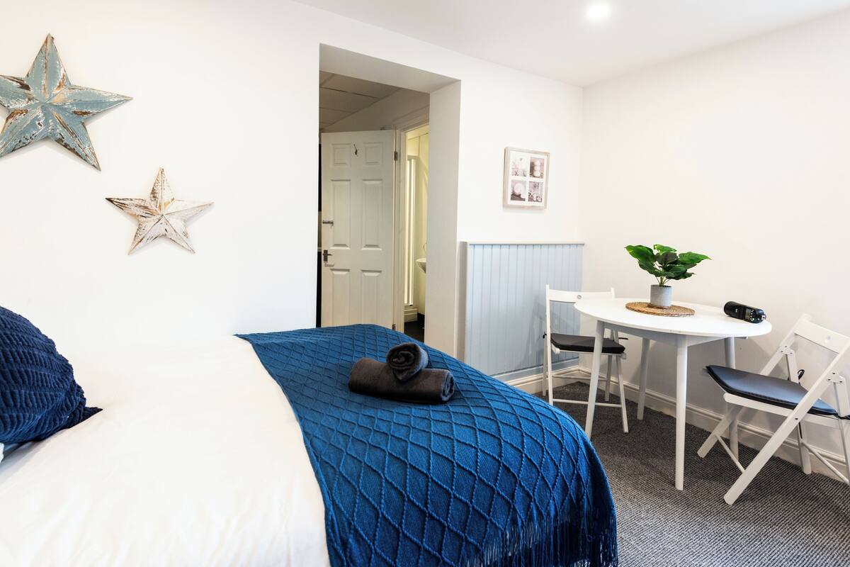 A room with a bed, a desk, and a chair.