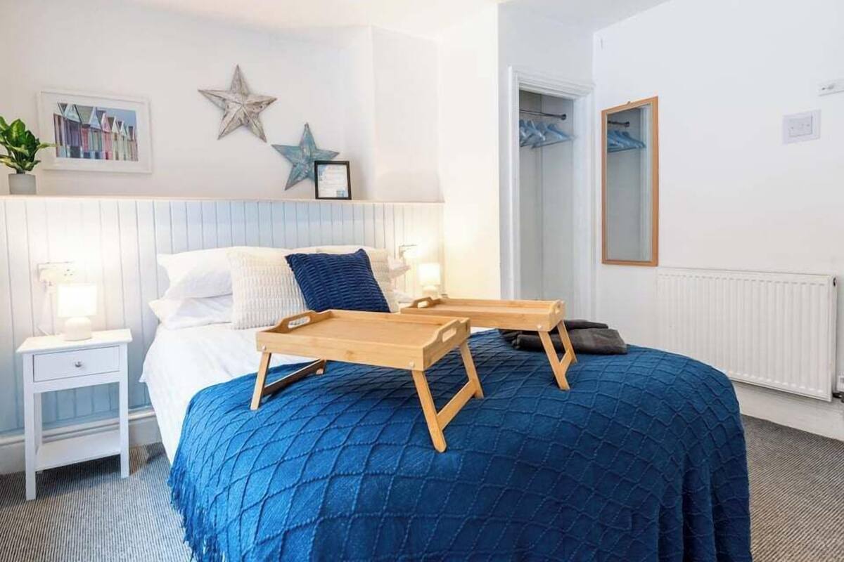 A bedroom with a bed, bedside table, and a wooden tray.