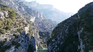 Un paysage montagneux avec un lac d’un bleu profond, entouré de falaises rocheuses.