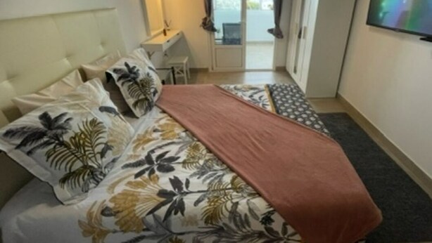 Ein Schlafzimmer mit einem Bett, einem Schreibtisch und einem Fernseher.