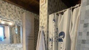 Ein Badezimmer mit gefliesten Wänden, einem Waschbecken und einer Duschkabine mit einem Cartoon-Motiv.