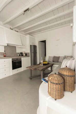 Een moderne keuken met witte kasten, een roestvrijstalen koelkast en een houten tafel.