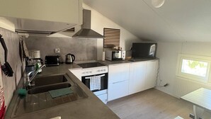 Cocina compacta con lavamanos, estufa y microondas.