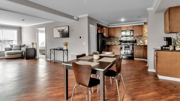 A modern kitchen with dark wood cabinets, a stainless steel refrigerator, and a built-in oven.