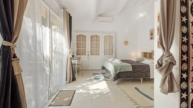 A room with a bed, a desk, a chair, a window with curtains, and a door. - Loft with Private Pool, Wi-Fi, and Air Conditioning (Boisset-et-Gaujac)