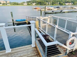 A dock with a white railing, a blue boat, and a water pump. - Beautiful cozy home w jacuzzi & dock for boat (New Haven)