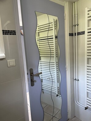 A bathroom with a door, a towel rack, and a mirror. - A stopover in the heart of the Basque Country (Halsou)