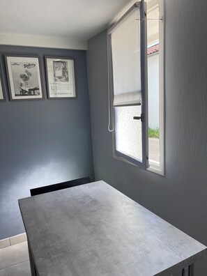 A room with a grey wall, a window with a white blind, and two framed pictures. - A stopover in the heart of the Basque Country (Halsou)