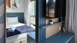 Een moderne hotelkamer met een bed, een tv aan de muur en een airconditioning.