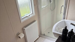 Ein kleines Badezimmer mit Toilette, Dusche und Waschbecken.