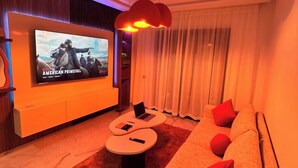 A modern living room with a flat-screen TV, a sofa, a coffee table, and a laptop on a round table. - Studio Luxe-Wintering-Pool/M'Avenue/2min Station (Marrakesh)