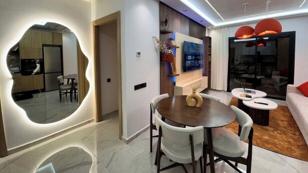 A modern living room with a dining area, a large mirror, and a television. - Studio Luxe-Wintering-Pool/M'Avenue/2min Station (Marrakesh)